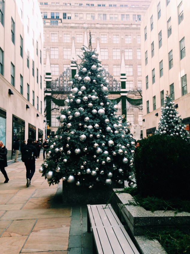 Christmas trees on Rockefeller Plaza with Saks Fifth Avenue in the background